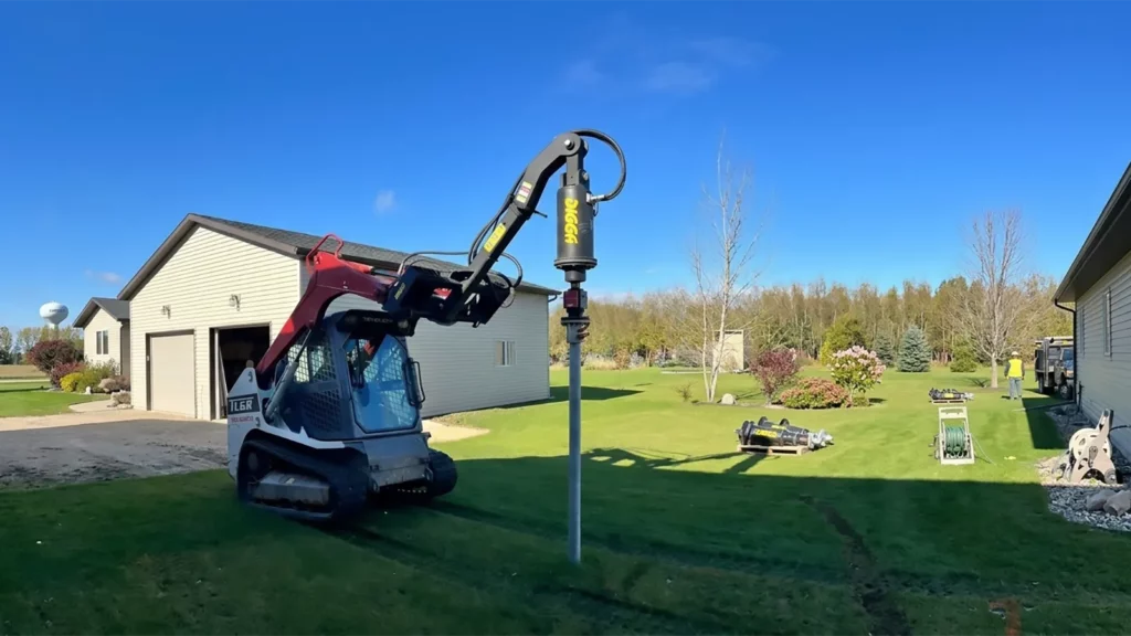 Construction crew installing helical screw piles at a commercial job site